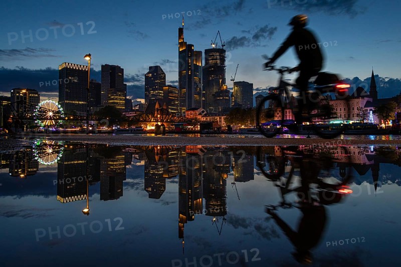 The colourful lights of the Mainfest are reflected in a puddle. The Mainfest on the Mainkai
