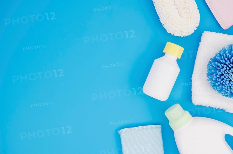 Different type sponges with detergent bottles blue backdrop