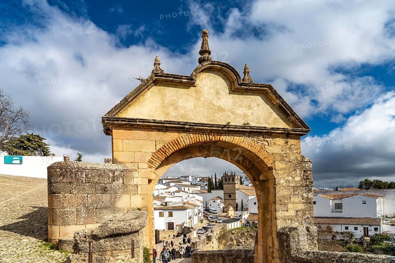 Archway Arco Felipe V and the white houses of the old town with the church Iglesia de Padre Jesus