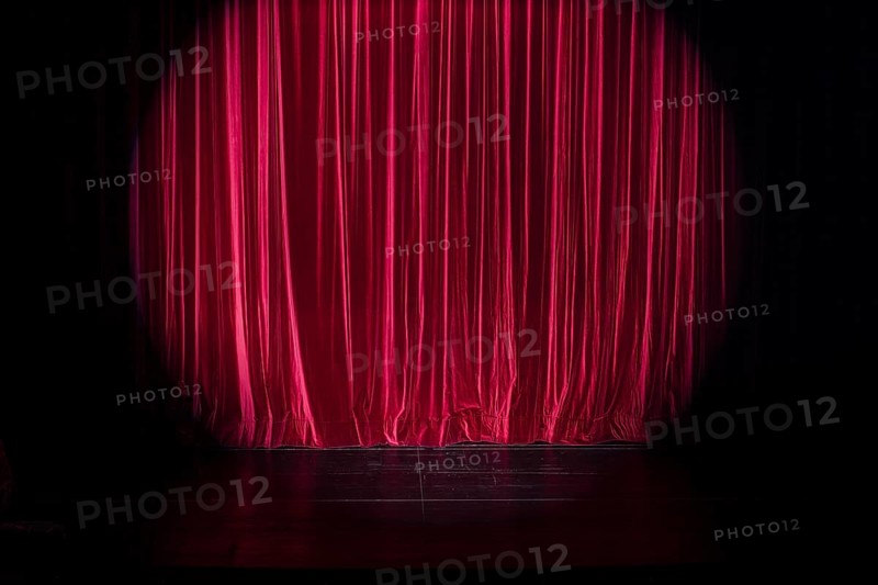 Empty stage with light spot on red curtain