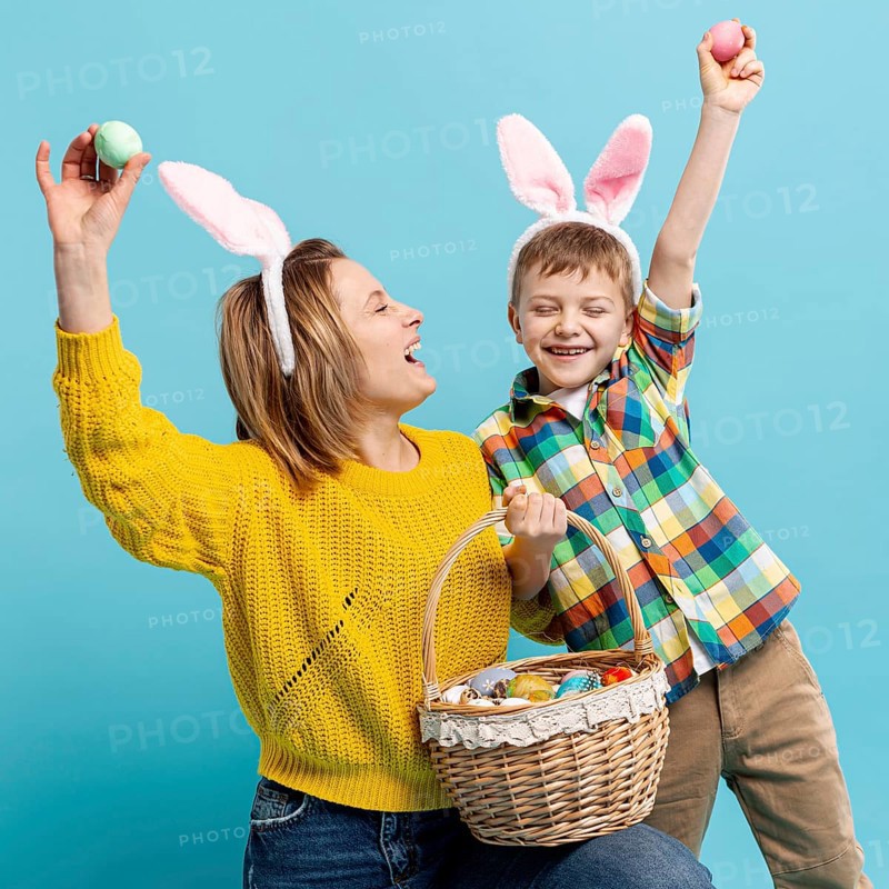 Playful mother son showing painted eggs