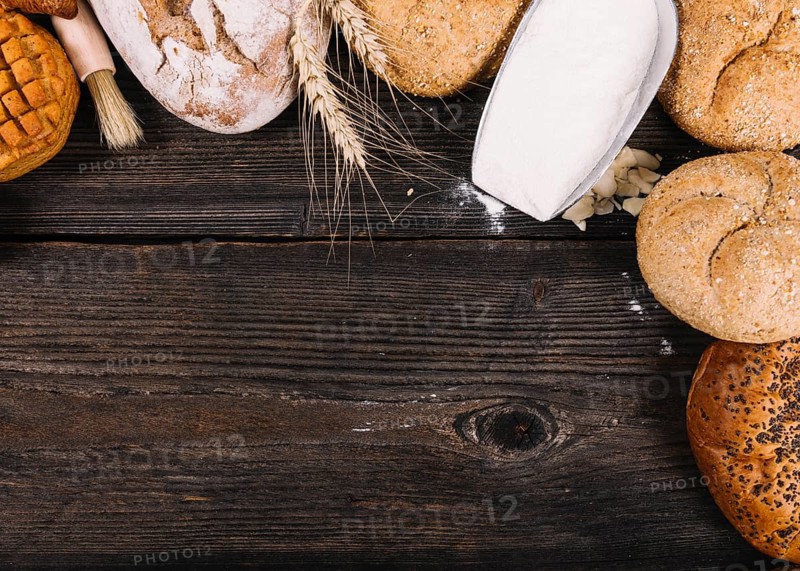 Overhead view flour shovel with baked breads table