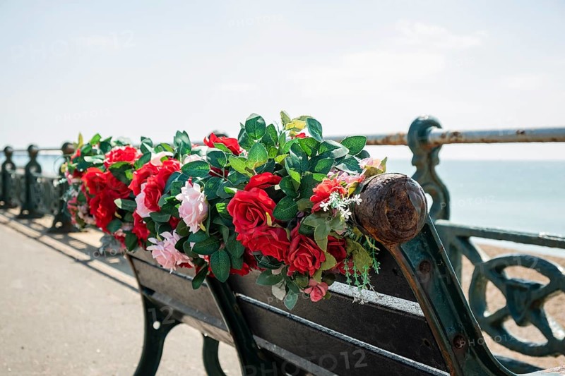 A bench with plastic flowers on the promenade in Brighton