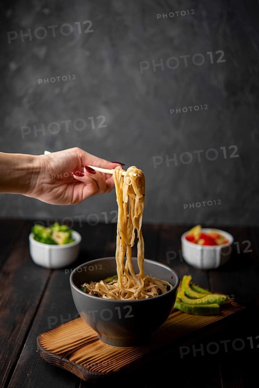 Noodles bowl with avocado copy space