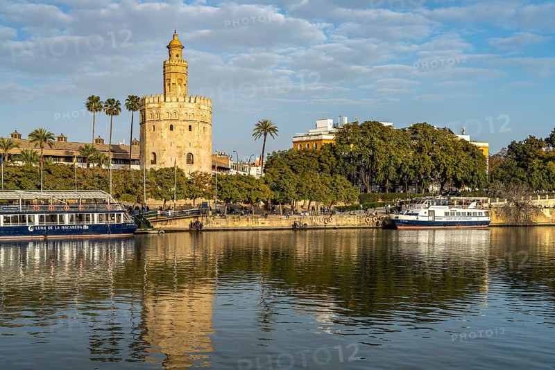 On the banks of the Guadalquivir river with the historic Torre del Oro tower in Seville