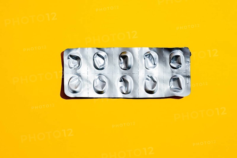 Empty tablet blister pack against yellow background