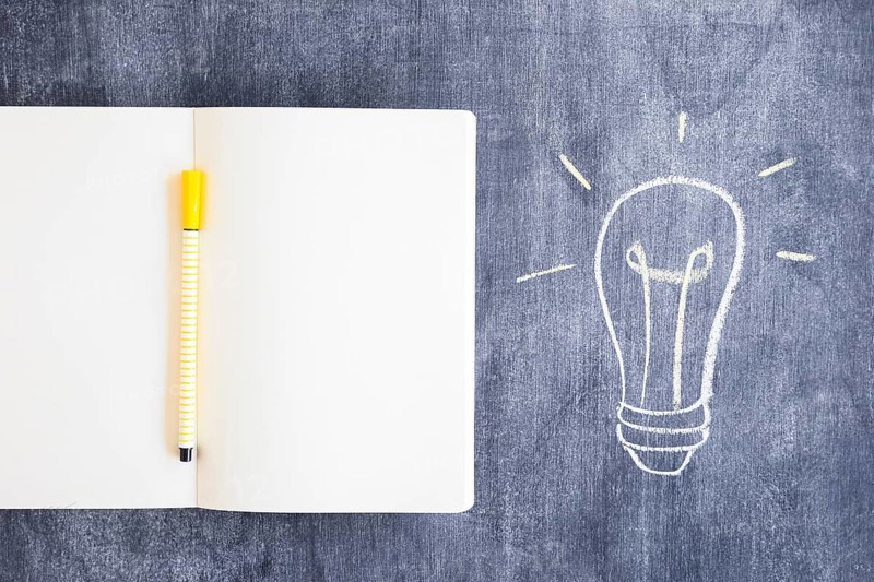 Felt tip pen blank notebook with drawn light bulb chalkboard
