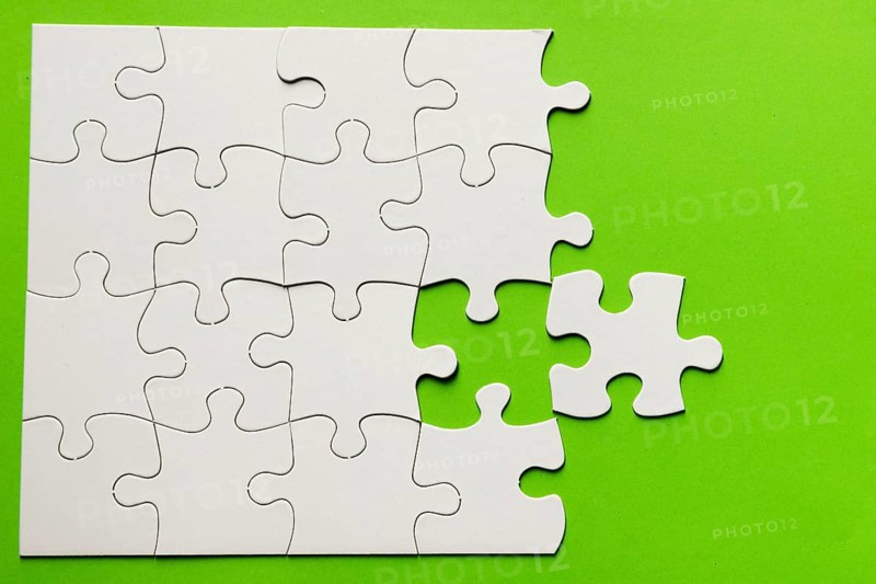 Elevated view cardboard puzzle green background