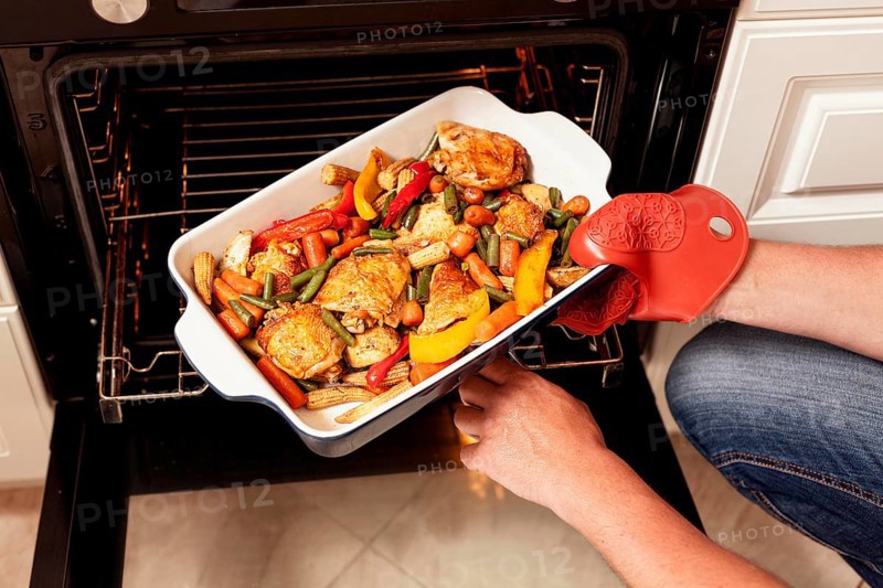 Tray food being put into oven cook