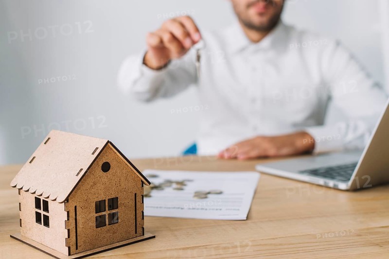House near real estate agent with keys