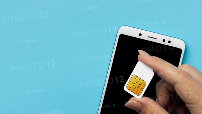Top view hand holding sim card with smartphone copy space