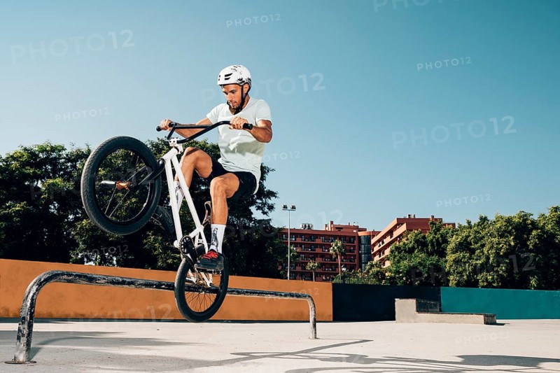 Teenage bmx rider performing tricks skatepark