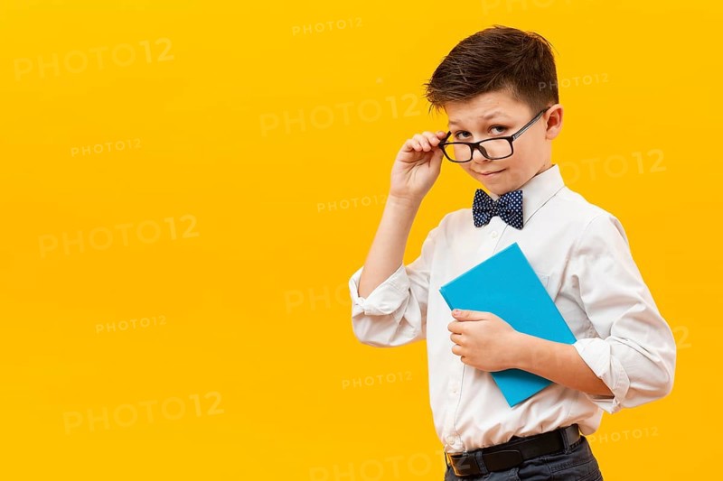 Young boy with glasses holding book