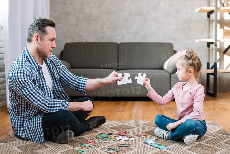 Father daughter hand holding jigsaw puzzle piece