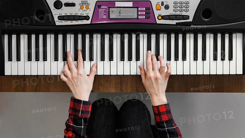 Top view hands playing digital piano