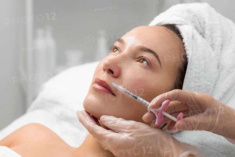 Beautician doing filler injection female client