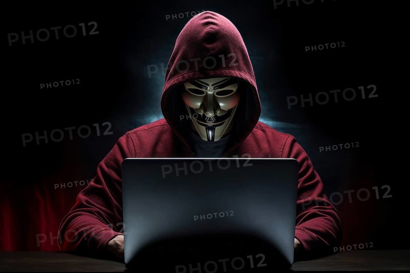 Hacker with Anonymous mask on notebook