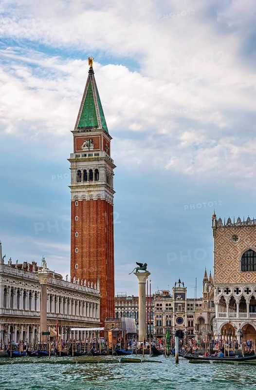 Famous view of St Mark campanile and columns with lion and saint by waterfront of piazzetta of St Mark square on Grand Canal