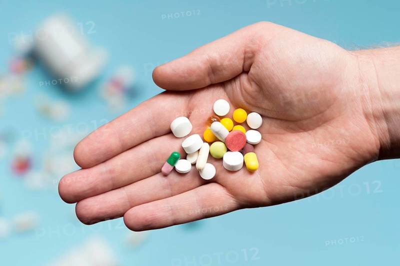 Flat lay hand holding assortment pills