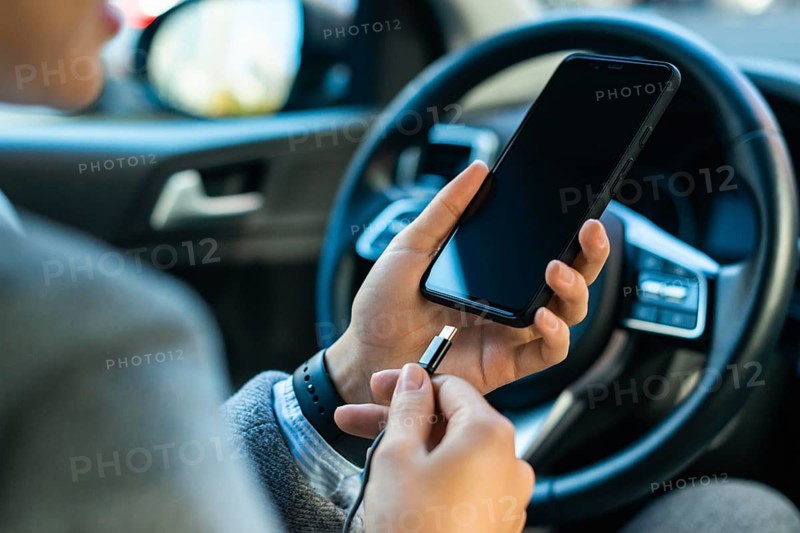 Businesswoman charging her phone car