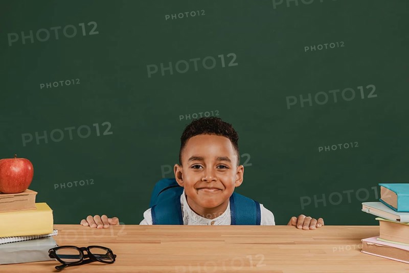 Cute boy with backpack hiding table