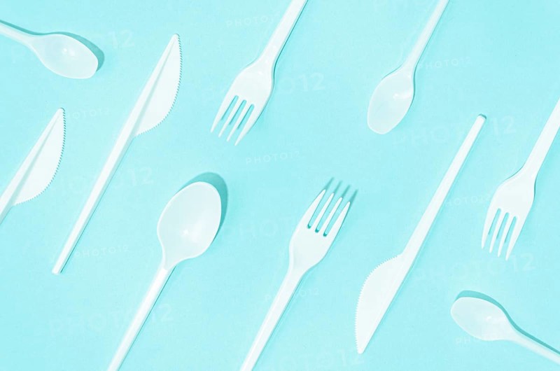 White disposable cutlery composition turquoise background