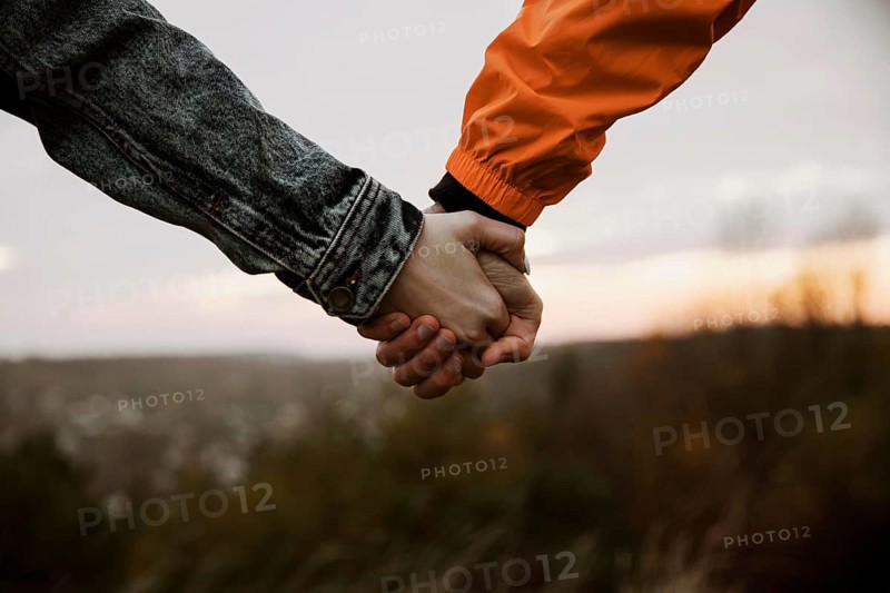Couple holding hands while road trip together