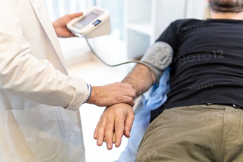 Doctor taking patient's blood pressure