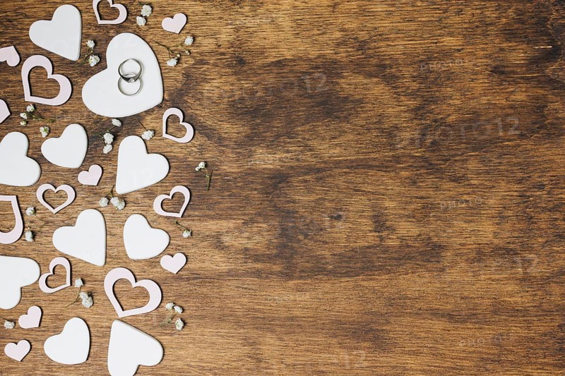 Overhead view silver wedding rings heart shape wooden backdrop