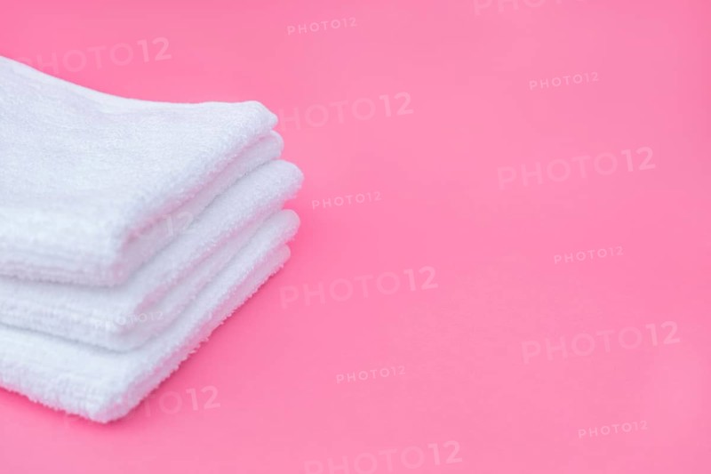 Stack white towels pink background