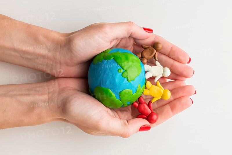 Top view hands holding plasticine globe people