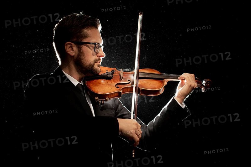 Side view male artist playing violin