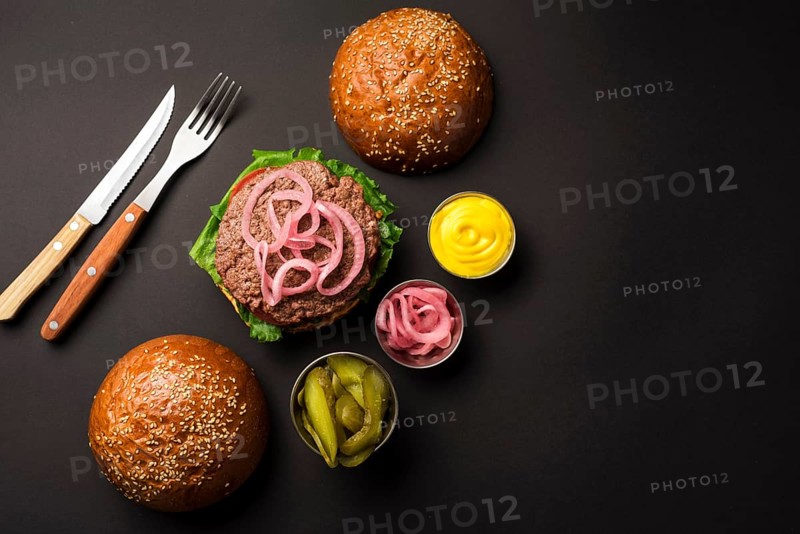 Top view beef burger with sauces cutlery