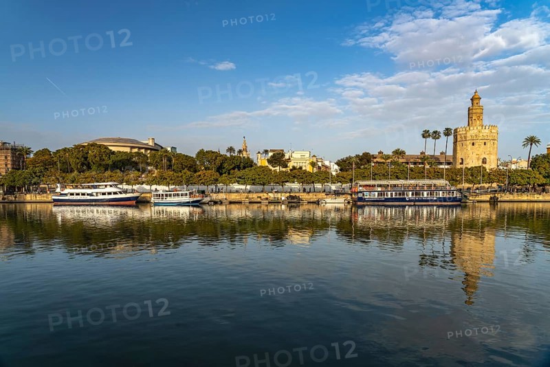 On the banks of the Guadalquivir river with the historic Torre del Oro tower in Seville