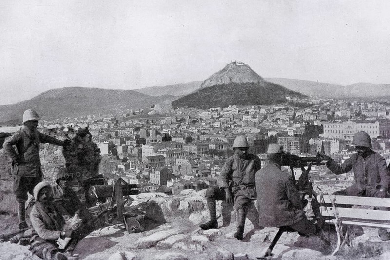 Greek soldiers stationed on the Acropolis with a canon and a machine gun in front of the Lycabettus mount