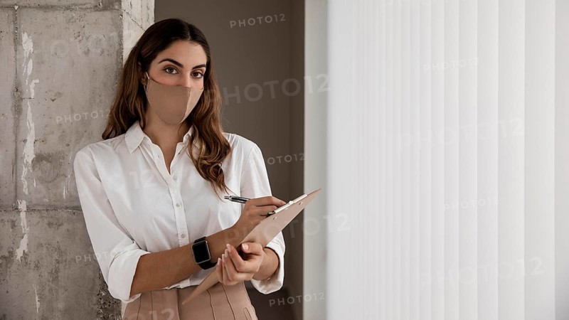 Front view businesswoman with mask clipboard