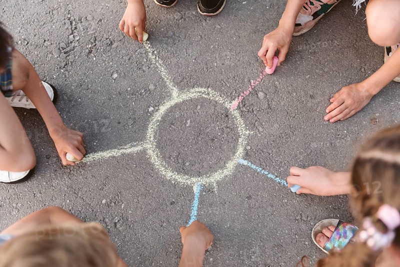 Kids drawing sun with chalk
