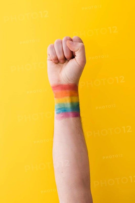 Person holding fist with rainbow flag wrist