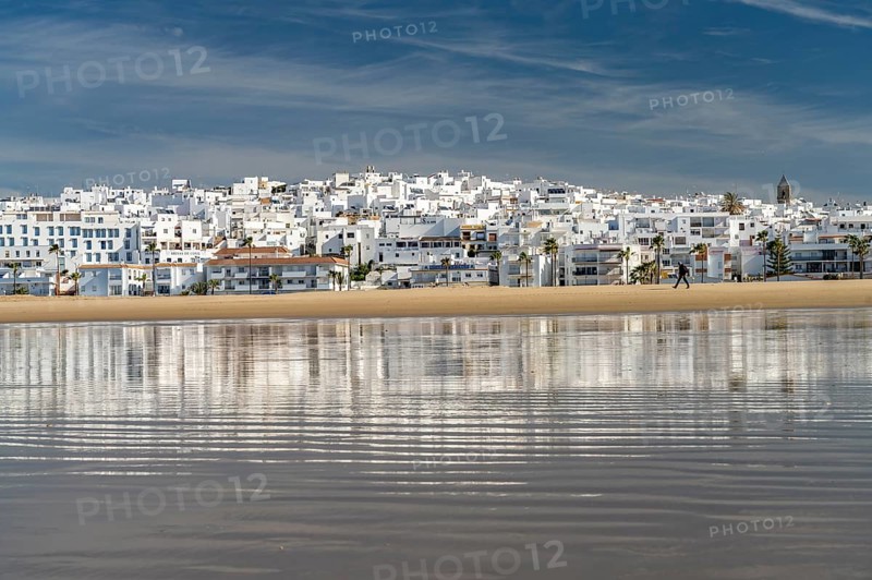 The town view of Conil reflected on the beach Playa De Los Bateles