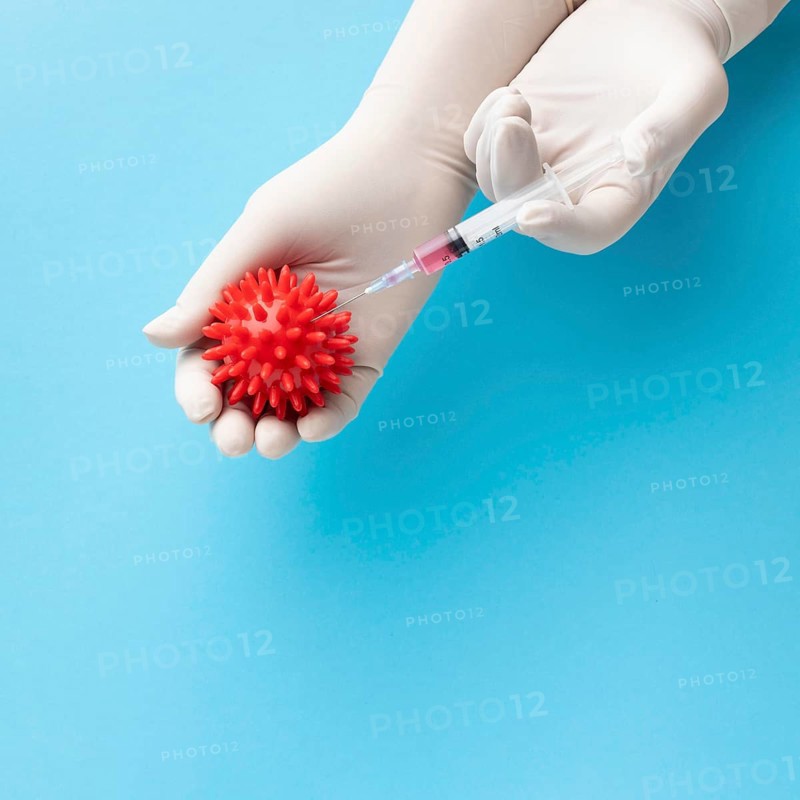 Top view hand holding virus syringe with vaccine
