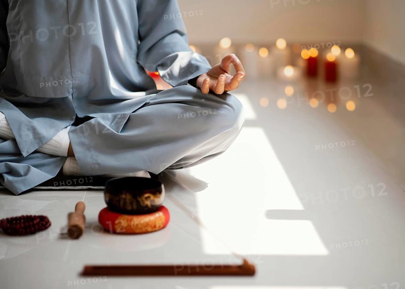 Front view woman meditating with incense candles