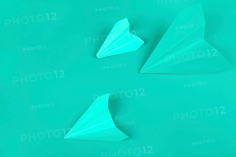 Overhead view green paper airplanes mint background