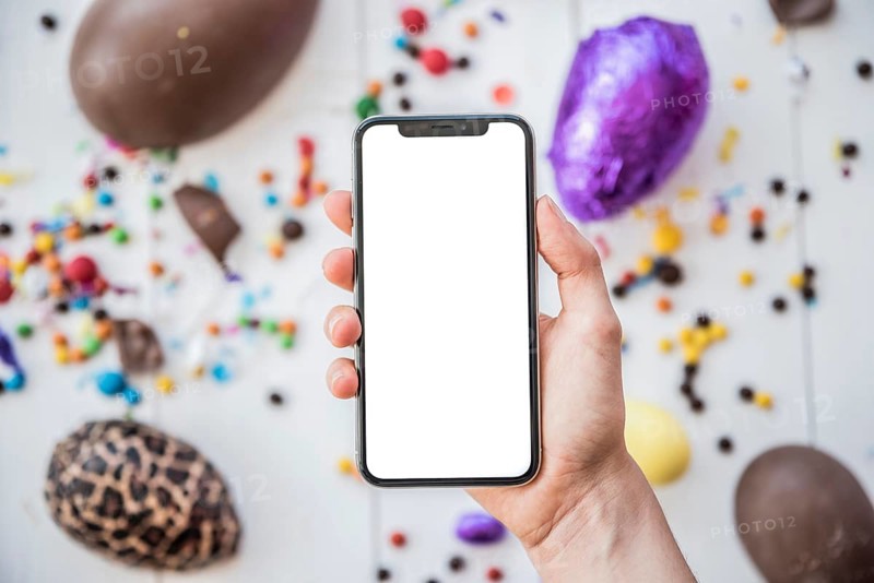 Person holding smartphone with blank screen easter eggs