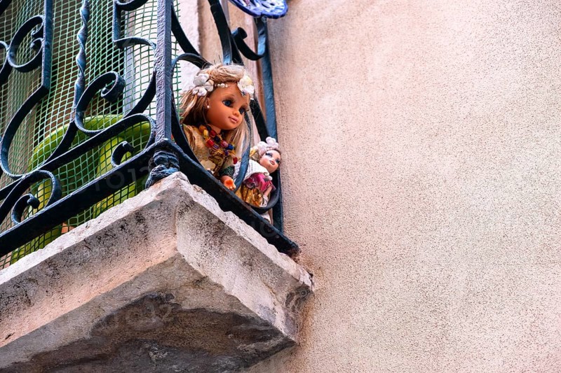 Two dolls on a balcony in Lisbon