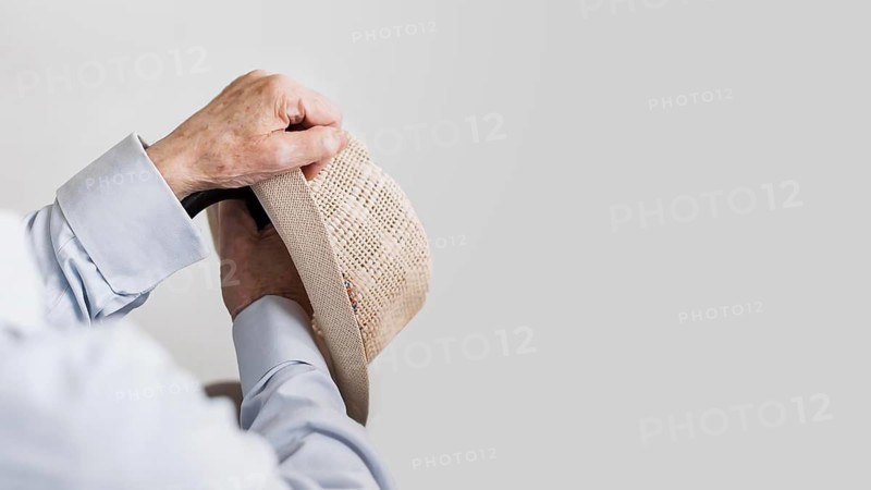 Old man holding hat cane