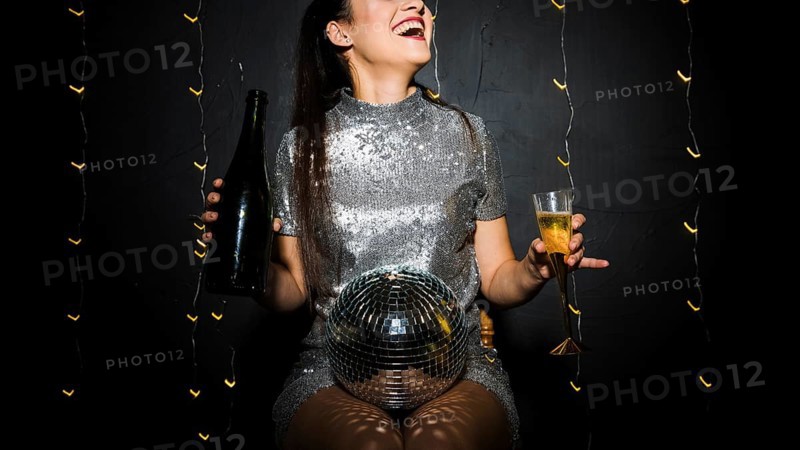 Smiling lady with disco ball bottle glass