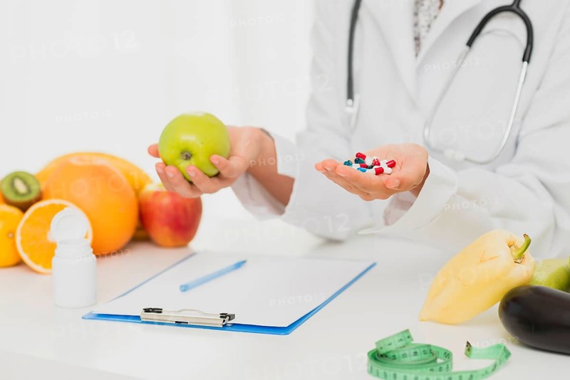 Doctor with pills fresh fruits