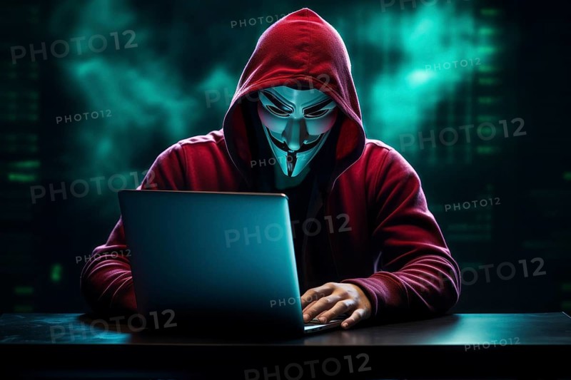 Hacker with Anonymous mask on notebook