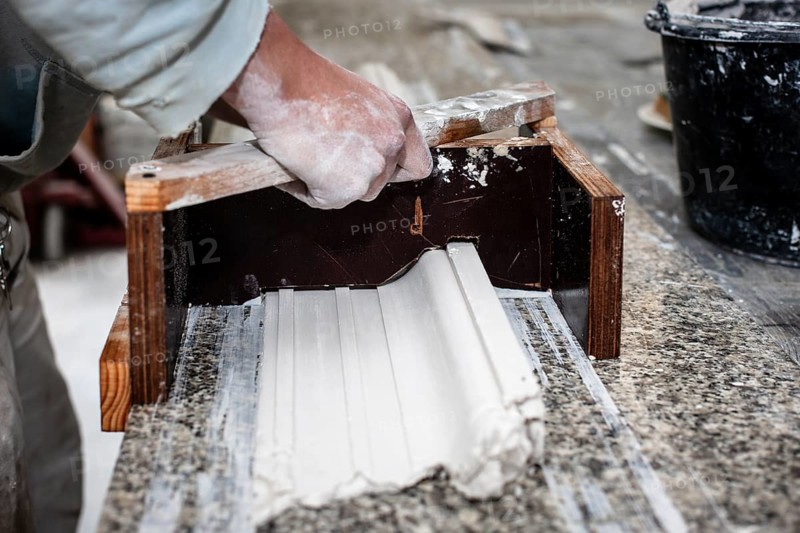 A plasterer creates a stucco profile