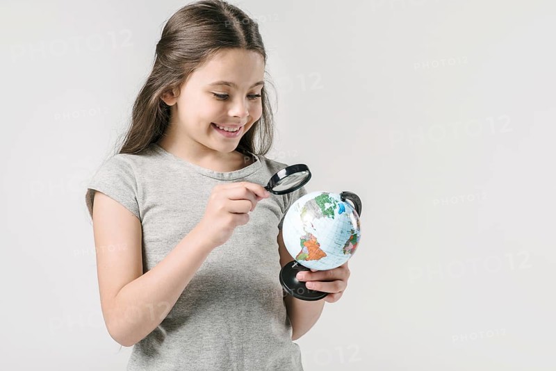 Junior girl studying globe loupe